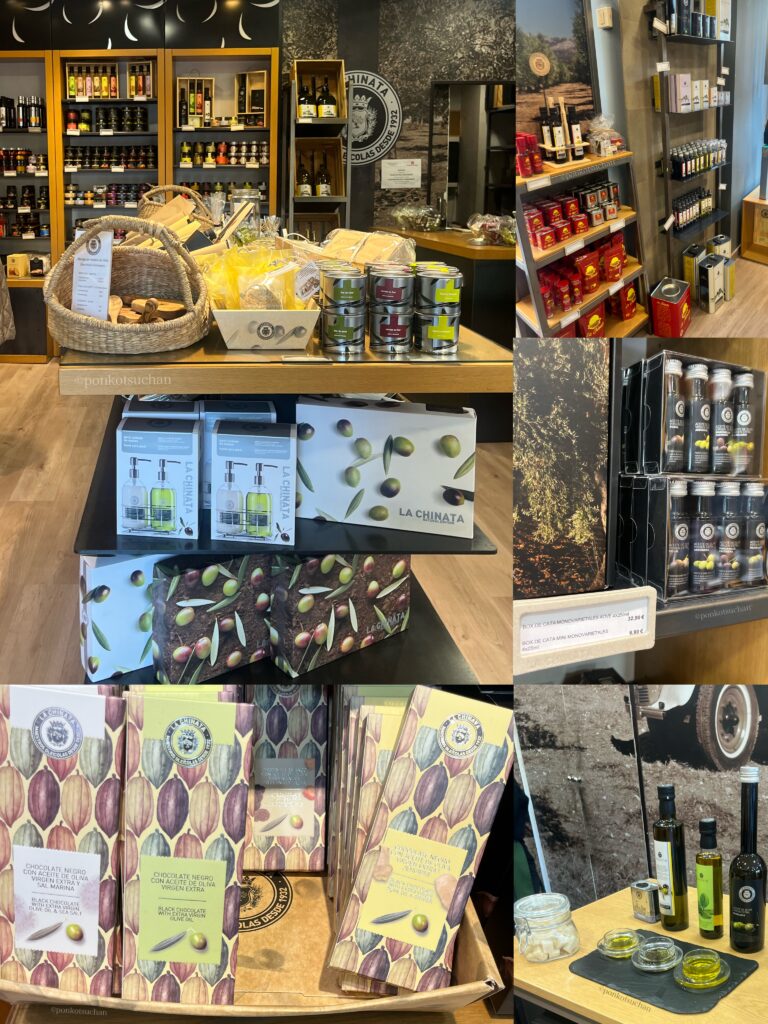 マドリードの人気オリーブオイル専門店『La Chinata（ラ・チナータ）』店内。エクストラバージンオリーブオイル、オリーブ石鹸、リップクリーム、チョコレート、調味料など、ギフトに最適なスペイン産オリーブ商品が整然と並ぶ。旅行者のお土産として特に人気の高いチョコレートシリーズやテイスティング用オイルのコーナーも写っている。