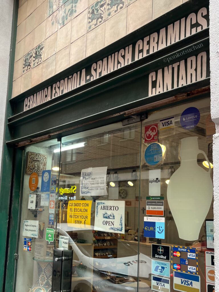 マドリード旧市街にあるスペイン陶器専門店CANTAROの外観。店先のガラス越しにハンドメイド陶器やスペイン伝統柄の食器が並び、グラナダやバレンシア産の陶器を扱う老舗店の雰囲気が伝わる。