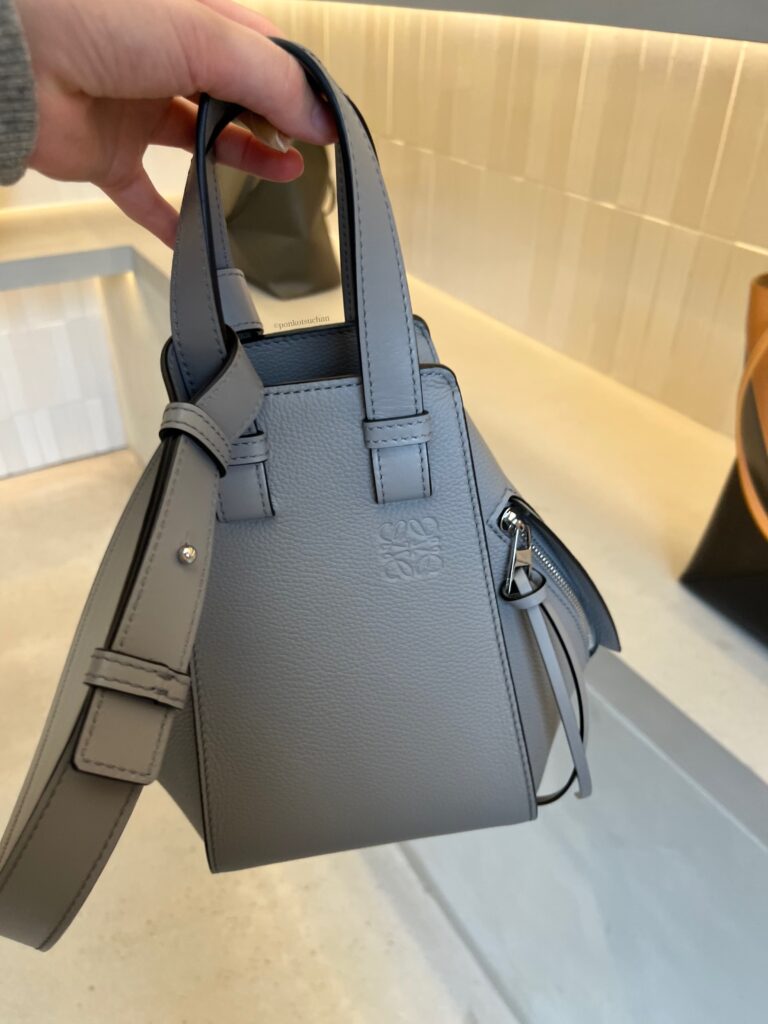 ロエベのハンモックバッグを手に持った写真。グレー系カラーとコンパクトなサイズ。