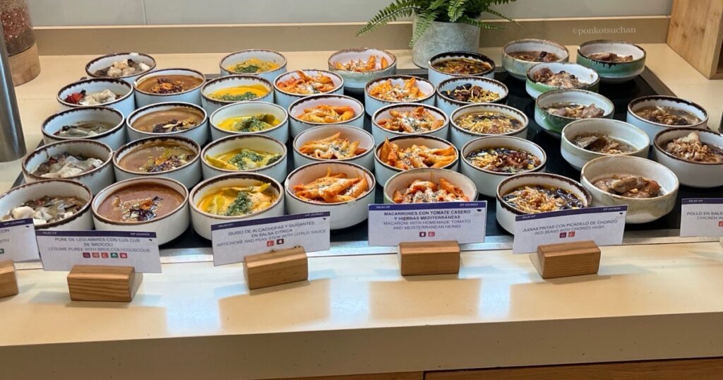 マドリード空港T4 Plaza Mayor(Sala VIP)ラウンジのビュッフェ全景。温菜やスペイン料理が小皿で豊富に並ぶ充実した食事内容。