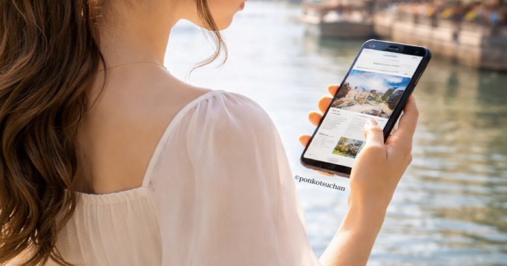 海外旅行中にスマホでKindleの旅行ガイドブックを読む女性の後ろ姿